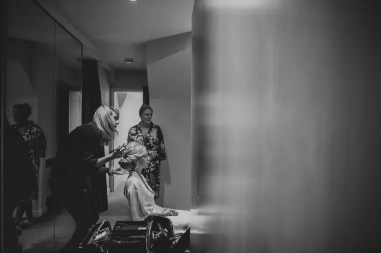 Black-and-white photo of the bride getting ready with her bridesmaids