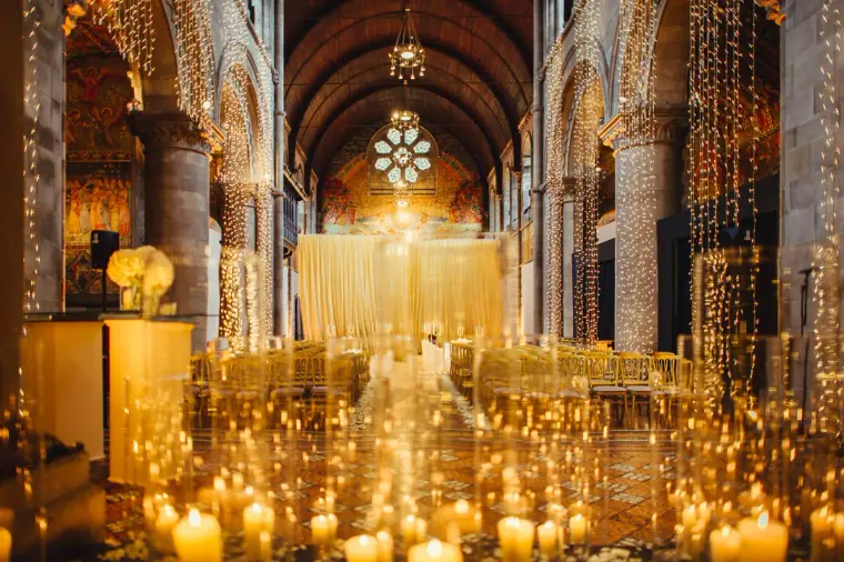 Candlelit aisle and draped ceremony backdrop inside Mansfield Traquair