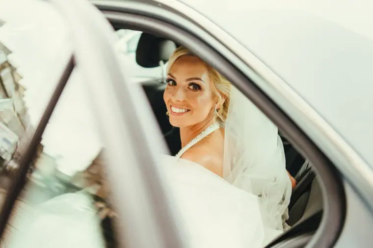 Leonnie smiling from the window of the wedding car