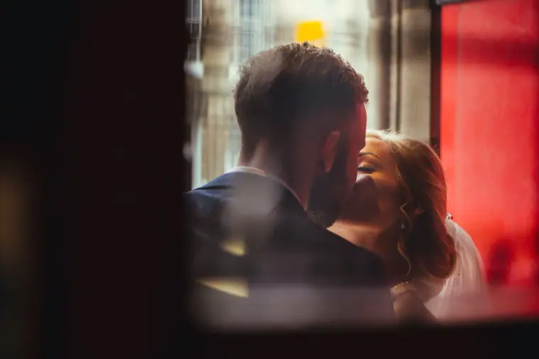 Couple kissing, glimpsed through a dark doorway