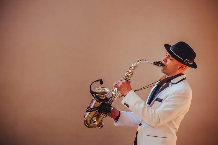 Saxophonist in a white jacket and fedora performing at the reception
