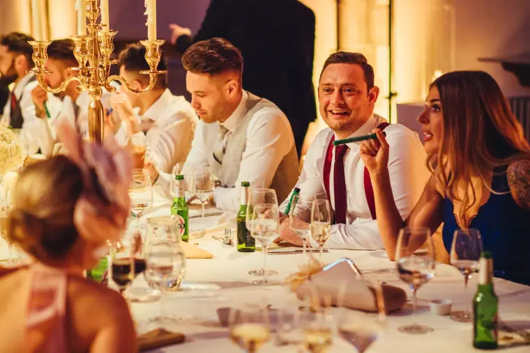 Guests laughing together at the candlelit reception table