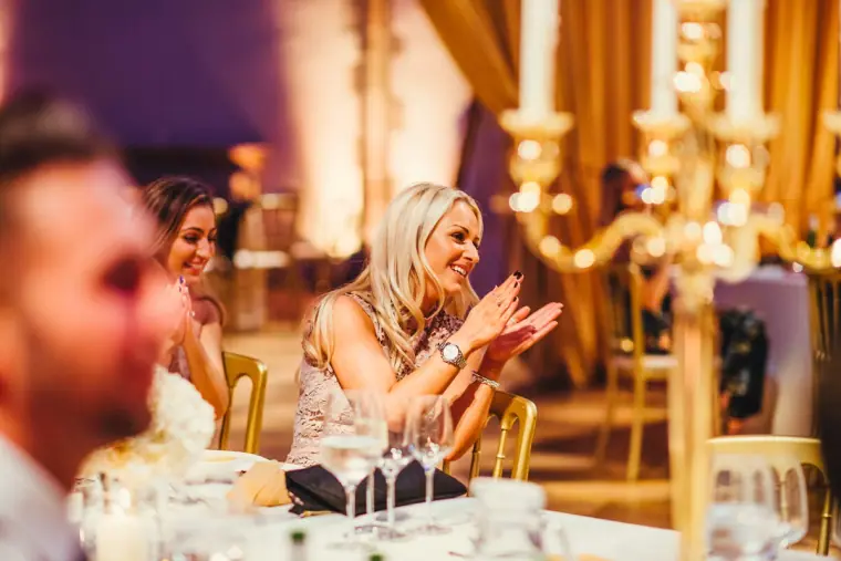 Guest applauding at the table beside a gold candelabra