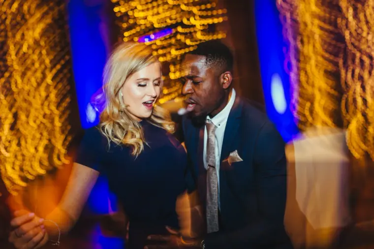 Guests dancing under swirling gold and blue lights