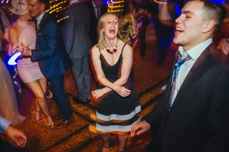 Guest in a striped dress laughing on the busy dance floor