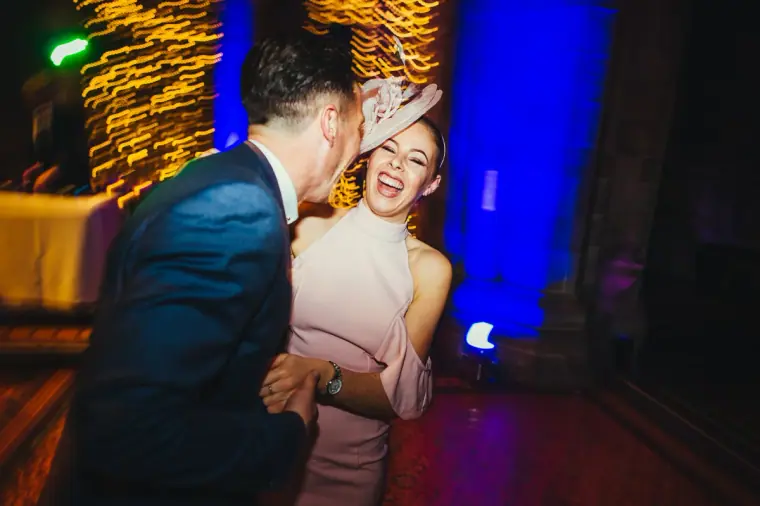 Couple laughing as they dance under blue and gold light
