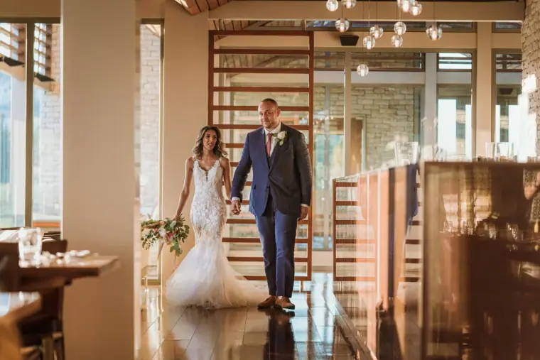 Newlyweds walking hand in hand through a modern restaurant