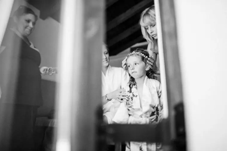 Black-and-white photo of a flower girl having her hair done