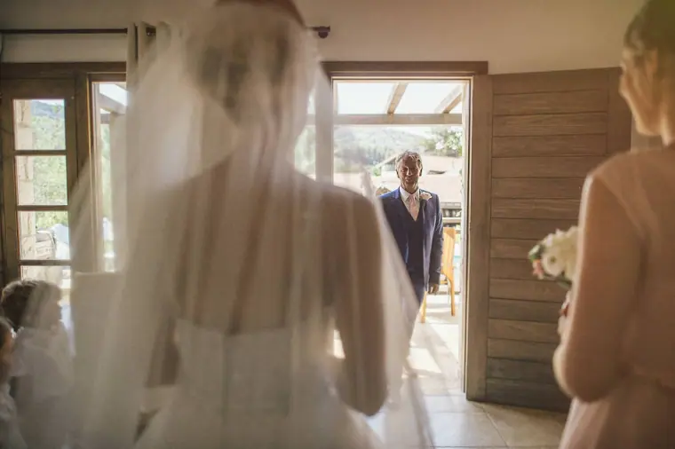 Bride in her veil about to walk through the doorway towards her father