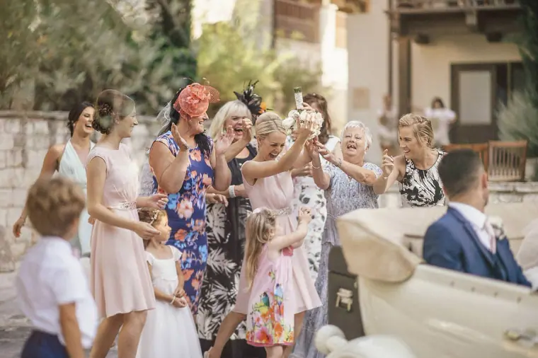 Female guests laughing and celebrating around the bouquet catch