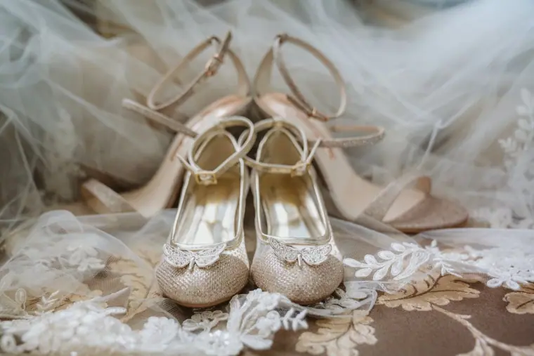 Bride's embellished gold heels resting on lace and tulle