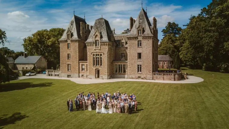 Aerial group photo of all the guests on the lawn in front of Château de la Basmaignée