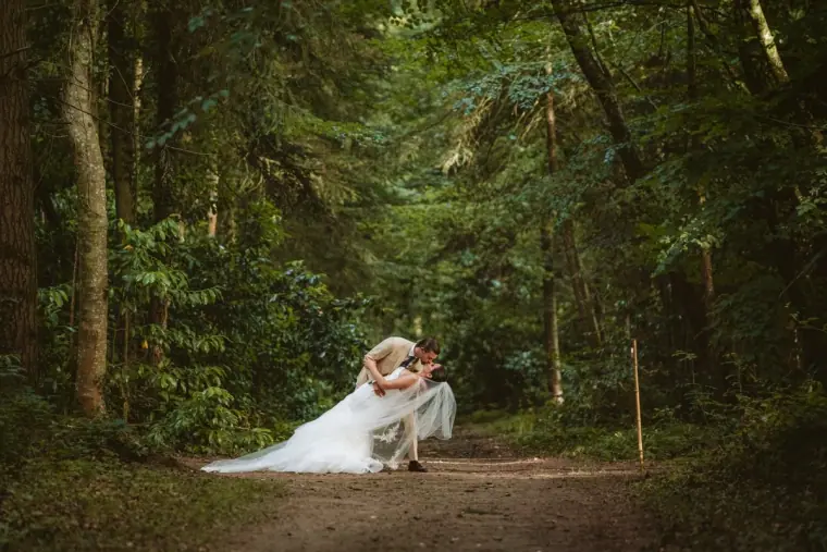 Josh dipping Lauren for a kiss on a woodland path