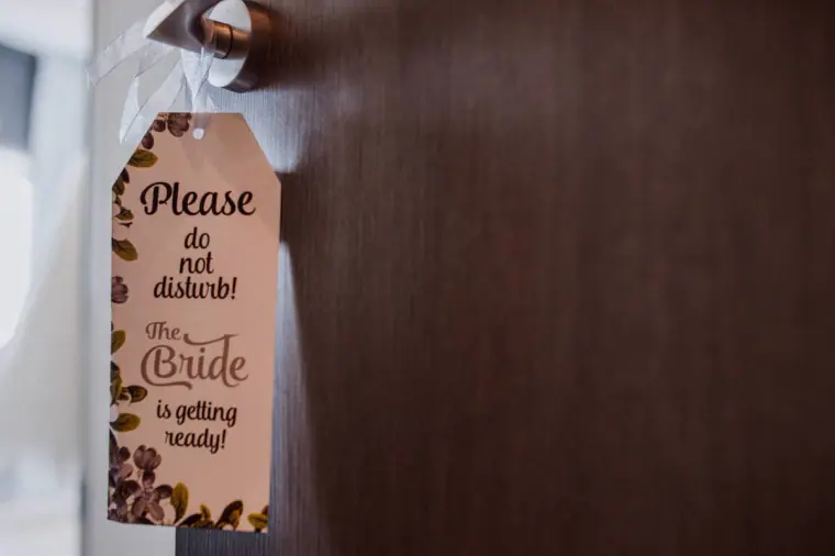 'Please do not disturb, the bride is getting ready' sign hanging on a door handle