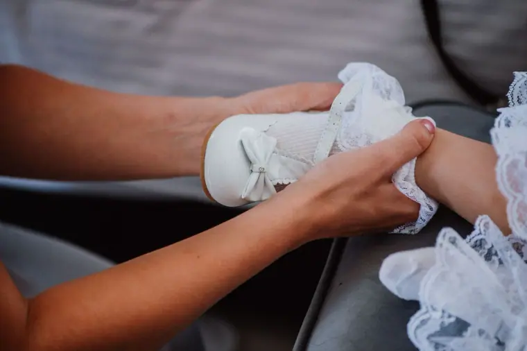 Hands fastening the lace-trimmed garter on the bride's leg