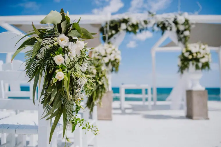 White floral arch dressed with greenery overlooking the sea at Galu Seaside, Larnaca