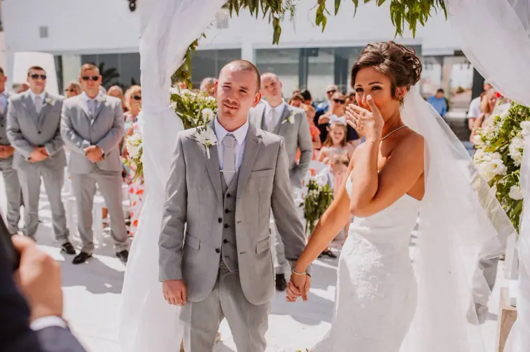 Mike smiling and Louise wiping a tear during the ceremony
