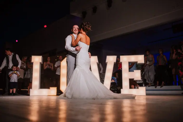 Louise and Mike's first dance behind giant light-up LOVE letters