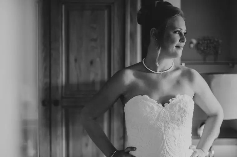 Black-and-white portrait of the bride in her strapless lace gown and pearls