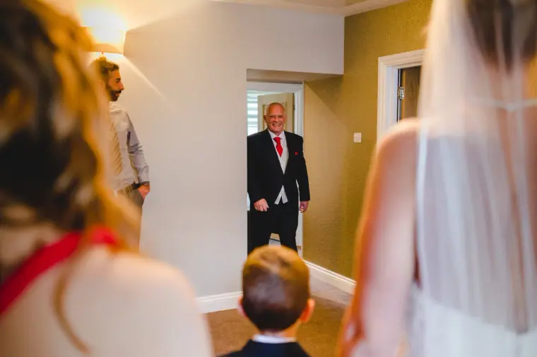 Father of the bride in a morning suit seeing his daughter for the first time