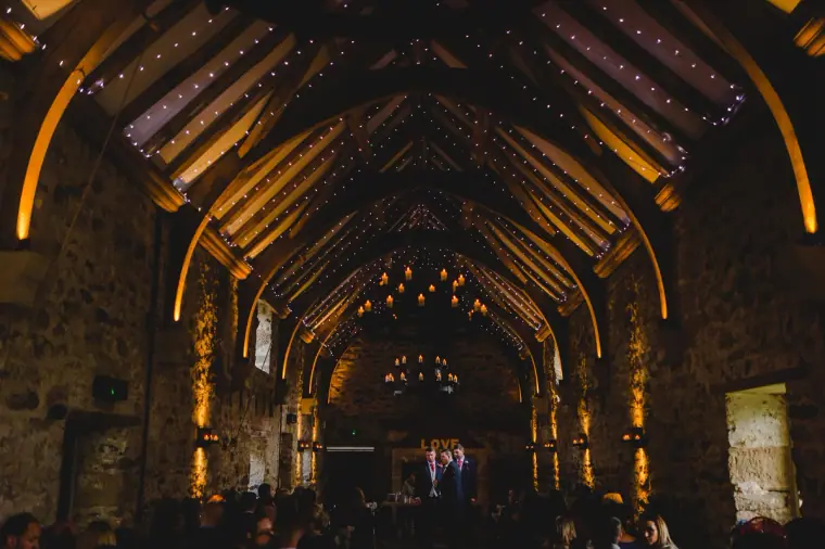 Fairy-lit vaulted roof of the stone ceremony hall at Healey Barn, Northumberland