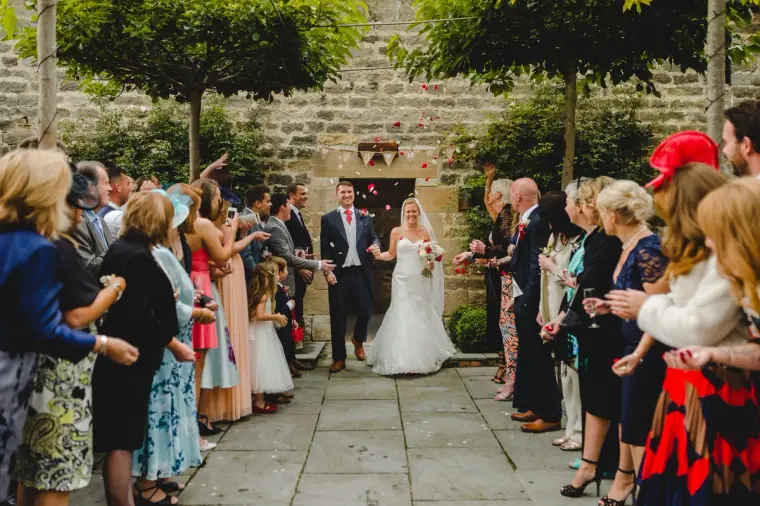 Guests cheering the couple as they enter the courtyard