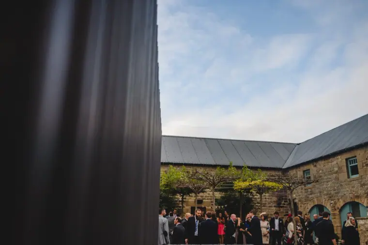 Guests gathered in the courtyard between the stone barns
