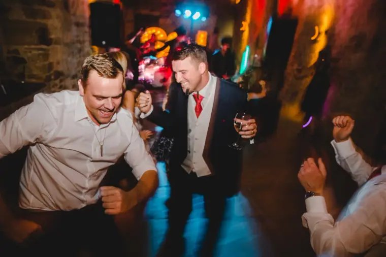 Guests dancing energetically beside the groom