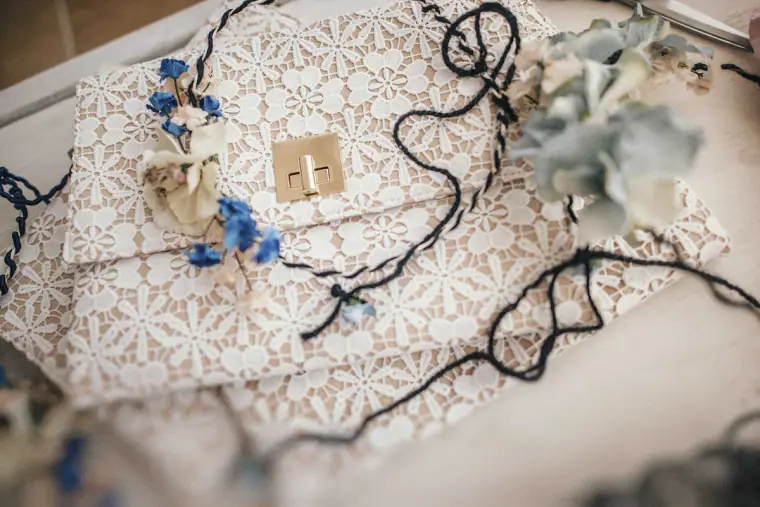 Lace clutch bag with blue and white flower accessories and black ribbon
