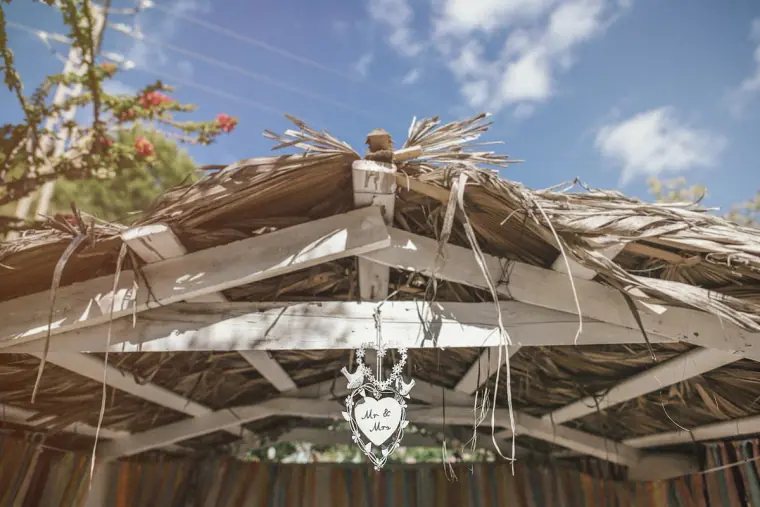 Thatched wooden pergola decorated with a hanging heart sign