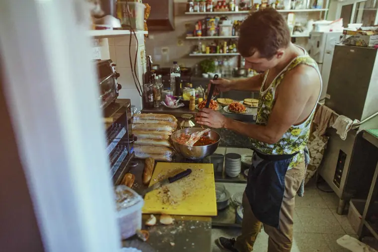 Chef preparing food in a busy rustic kitchen