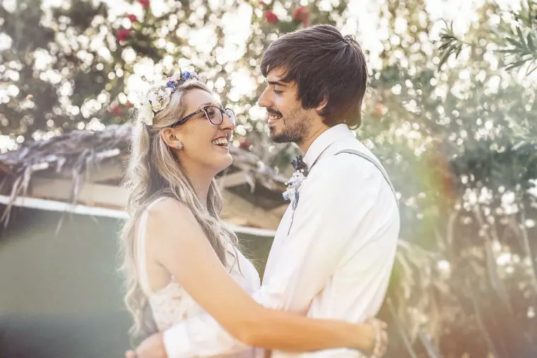 Bride and groom smiling at each other in hazy sunlight