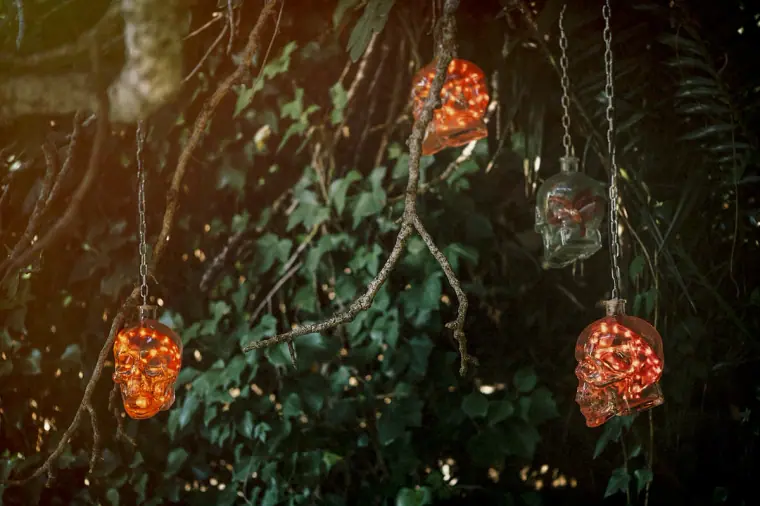 Red glass skull lanterns hanging among ivy