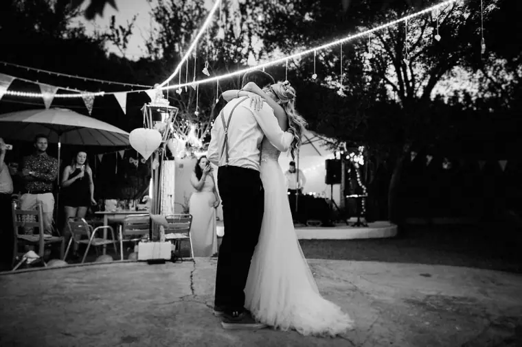Black-and-white first dance under festoon lights and bunting