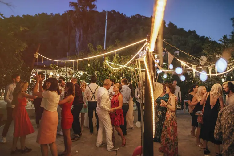 Outdoor dance floor busy with guests under festoon lights at Hidden Bar