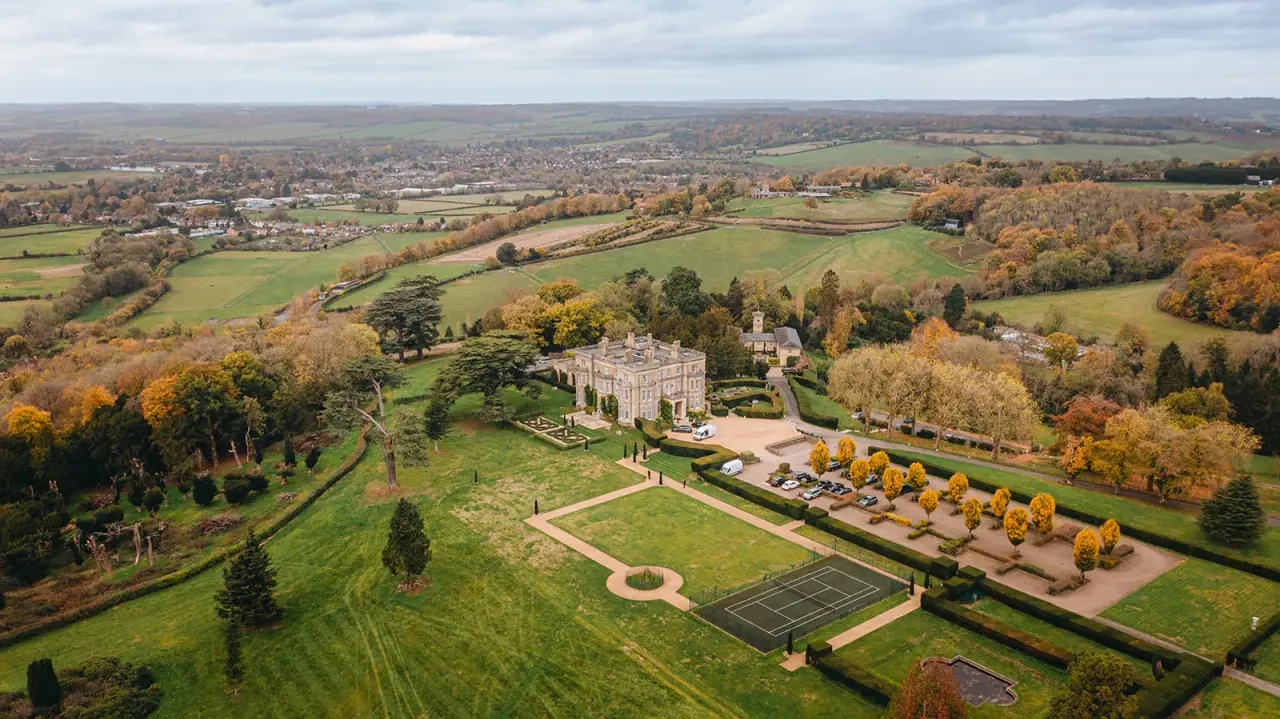 Aerial view of Hedsor House and its formal gardens amid autumn countryside