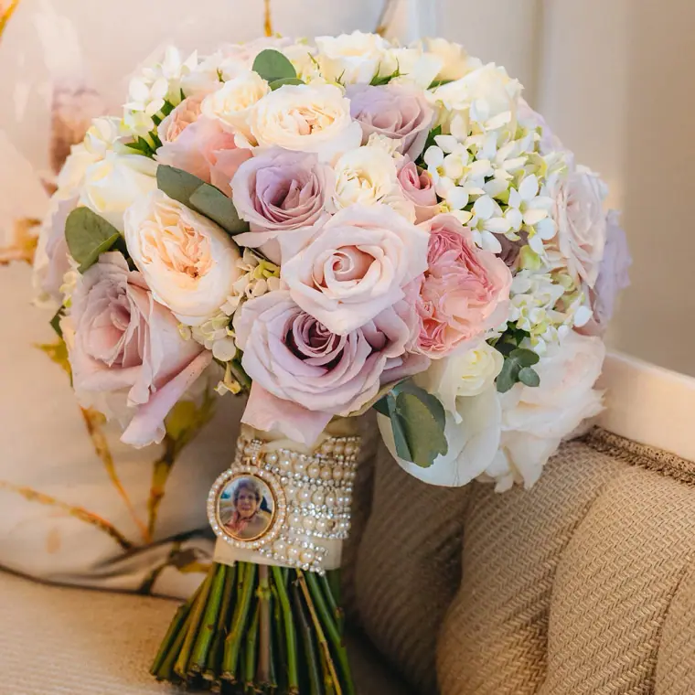Pastel rose bouquet with a memorial photo charm on the stem wrap