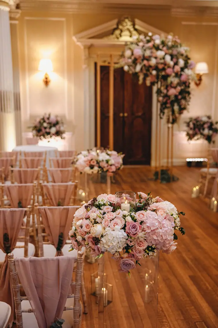 Floral arch and pink aisle arrangements in the ceremony room at Hedsor House