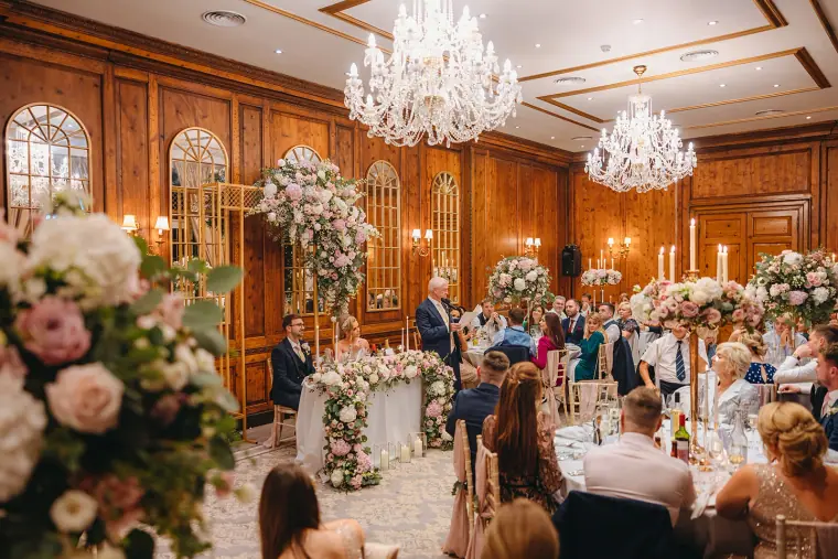Guests seated for the wedding breakfast in the chandelier-lit dining room