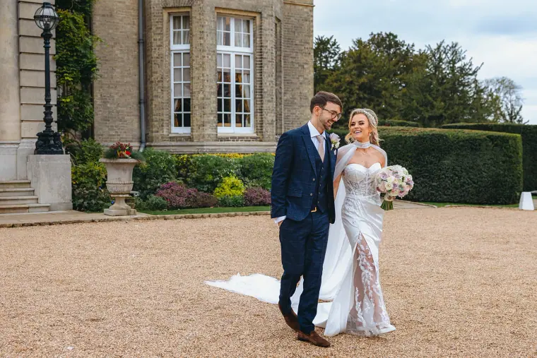 Ian and Jade walking across the gravel forecourt of Hedsor House