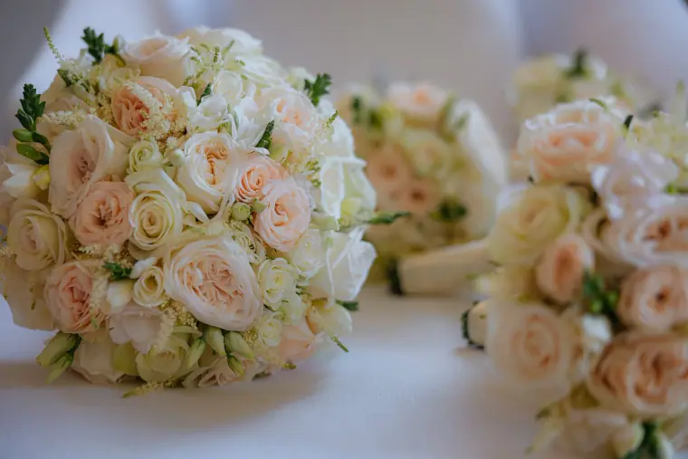 Blush and ivory rose bouquets resting on a table