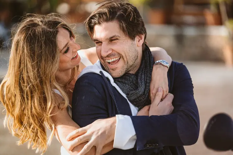 Antonia and Birger laughing together, arms wrapped around each other, at their Ibiza party