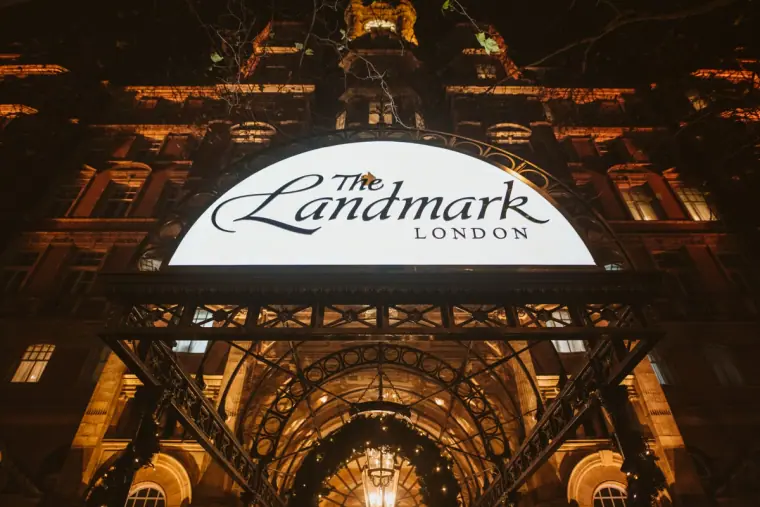 Illuminated sign of The Landmark London above the hotel's glowing arched entrance at night
