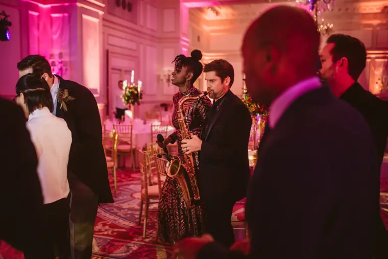 Saxophonist playing among guests in the ballroom at The Landmark London