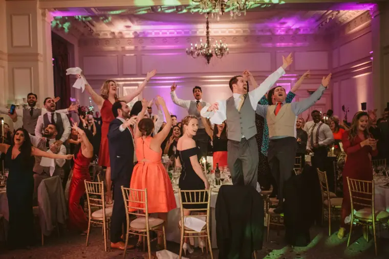 Guests cheering and throwing napkins in the air during the reception at The Landmark London