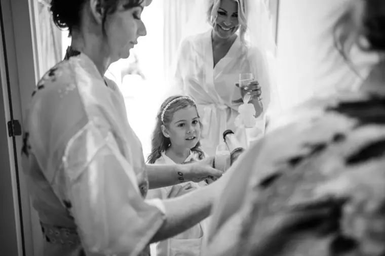 Black-and-white photo of the bride's mother and flower girl getting ready together