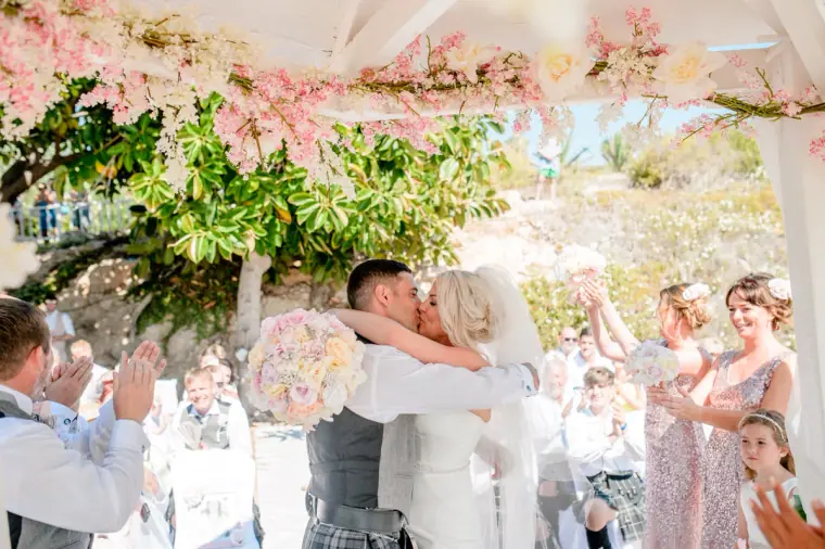 Maryellen and Ben's first kiss under the blossom-trimmed gazebo as guests cheer