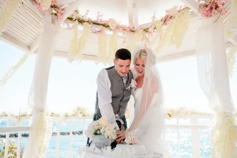 Bride and groom signing the register at a table inside the gazebo