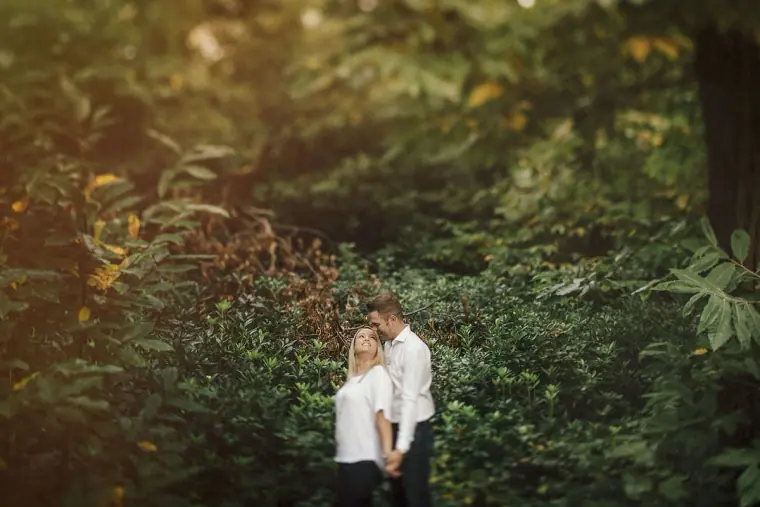 Couple sharing a quiet moment among dense green foliage at Virginia Water