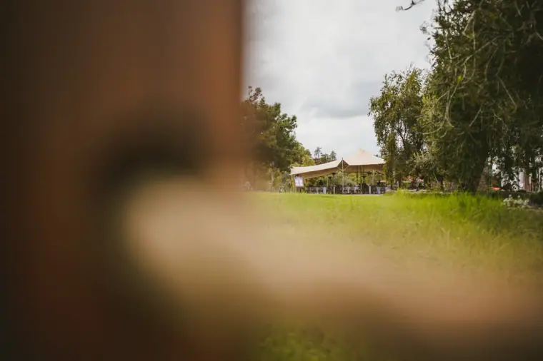 Stretch tent on a lawn seen past a blurred wooden post at Lexeko Estate